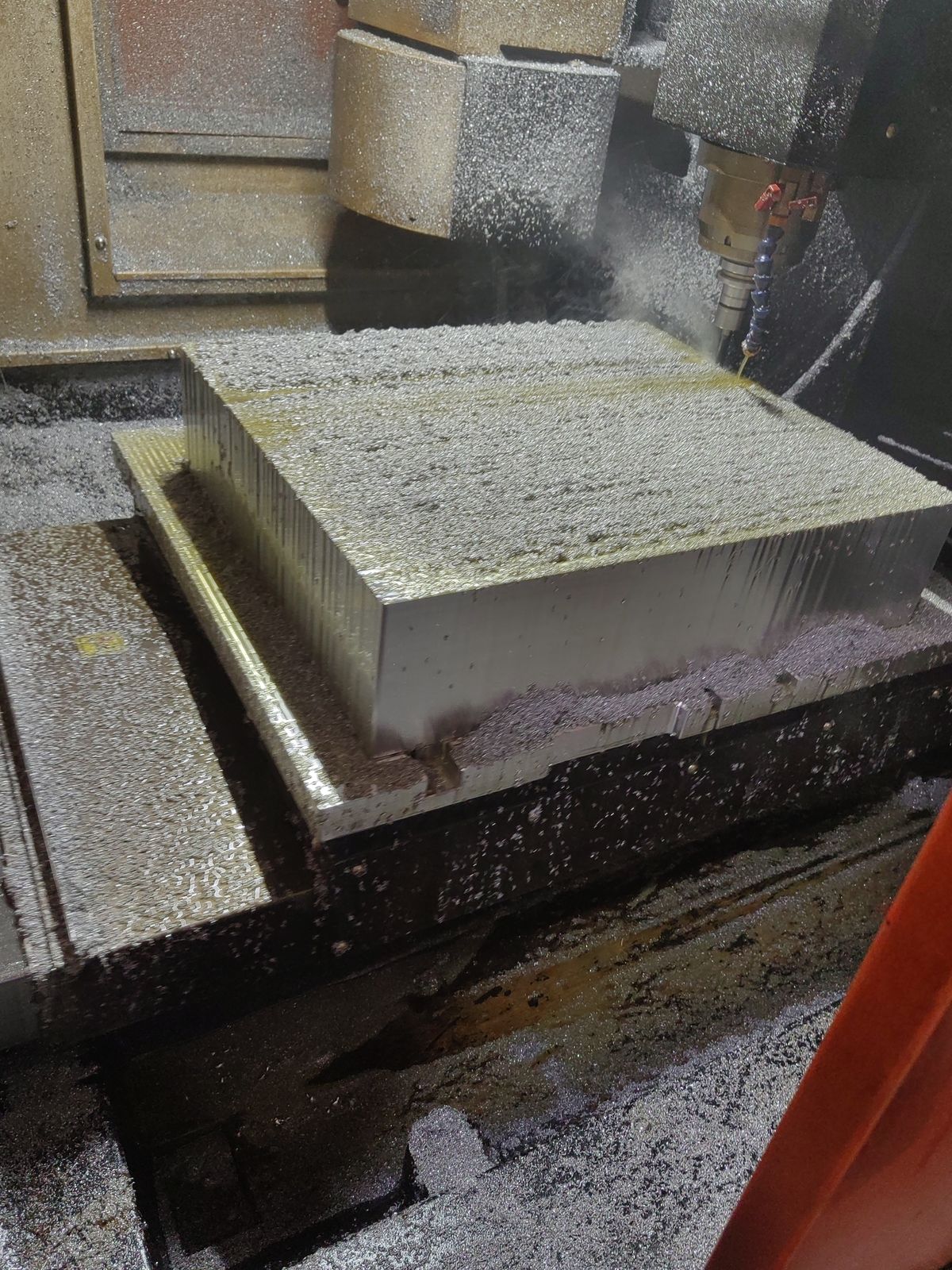 Aluminum block being milled with chips flying